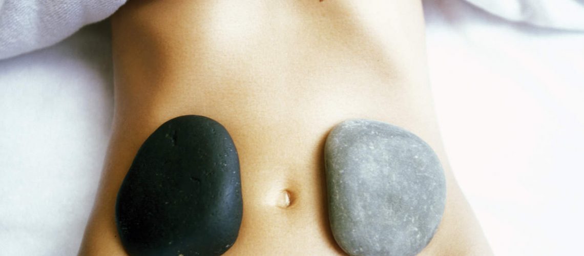 Woman with stones on stomach